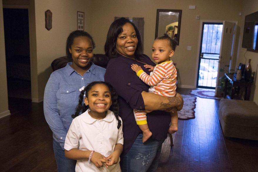 In a March 10, 2016 photo, Tamika Walker, second from right, poses with her daughters, from left, Tamia, 17, Camryn, 8, and Camylle, 1, in their home in the Wolf River Bluffs neighborhood in Memphis, Tenn. After 10 years of discipline to clear up $25,000 in credit card and car-loan debts as well as a credit history that included bankruptcy, Tamika and her husband Clarence Walker bought a house. For the same amount they had been paying in rent, Tamika said. (Brandon Dill/Special to The Commercial Appeal)