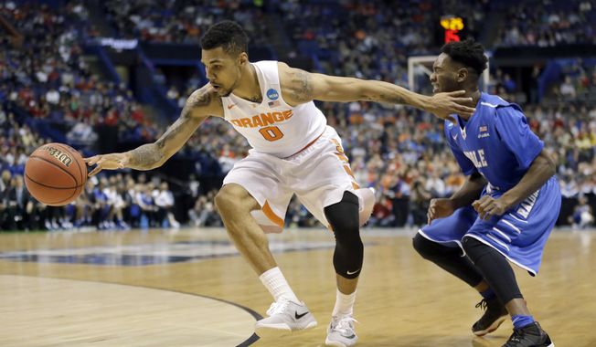 Syracuse&#x27;s Michael Gbinije, left, reaches for the ball alongside Middle Tennessee&#x27;s Quavius Copeland during the first half in a second-round men&#x27;s college basketball game in the NCAA Tournament, Sunday, March 20, 2016, in St. Louis. (AP Photo/Jeff Roberson)