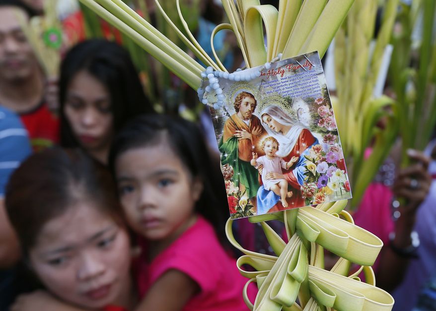 Roman Catholic devotees carry palm fronds to be blessed by a priest as they commemorate Palm Sunday which marks the beginning of Holy Week Sunday, March 20, 2016 at the Redemptorist Church in Baclaran, south of Manila, Philippines. Palm Sunday, which is the final week of Lent, marks the triumphant entry of Jesus Christ into Jerusalem. The palm fronds end up in homes of devotees for a year, to be burned after and its ashes to be used for Ash Wednesday for next Season of Lent. (AP Photo/Bullit Marquez)