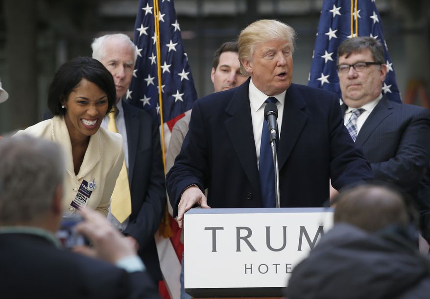 Alicia Watkins of Gaithersburg, Md., left, reacts as she talks to Republican presidential candidate Donald Trump after asking him for a job, while he was speaking during a campaign event in the atrium of the Old Post Office Pavilion, soon to be a Trump International Hotel, Monday, March 21, 2016, in Washington. (AP Photo/Alex Brandon)
