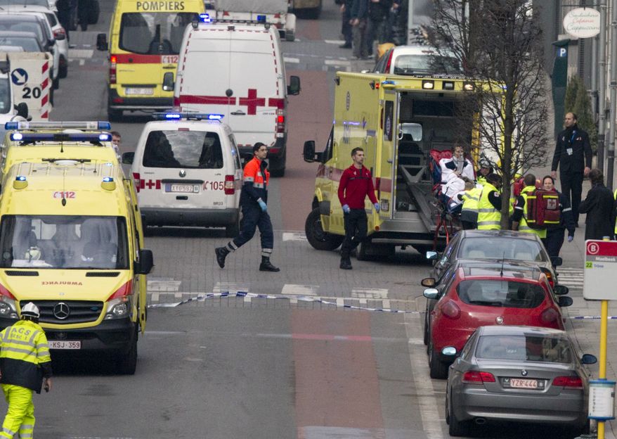 A woman is evacuated in an ambulance by emergency services after a explosion in a main metro station in Brussels on Tuesday, March 22, 2016. Explosions rocked the Brussels airport and the subway system Tuesday, killing at least 13 people and injuring many others just days after the main suspect in the November Paris attacks was arrested in the city, police said. (AP Photo/Virginia Mayo)