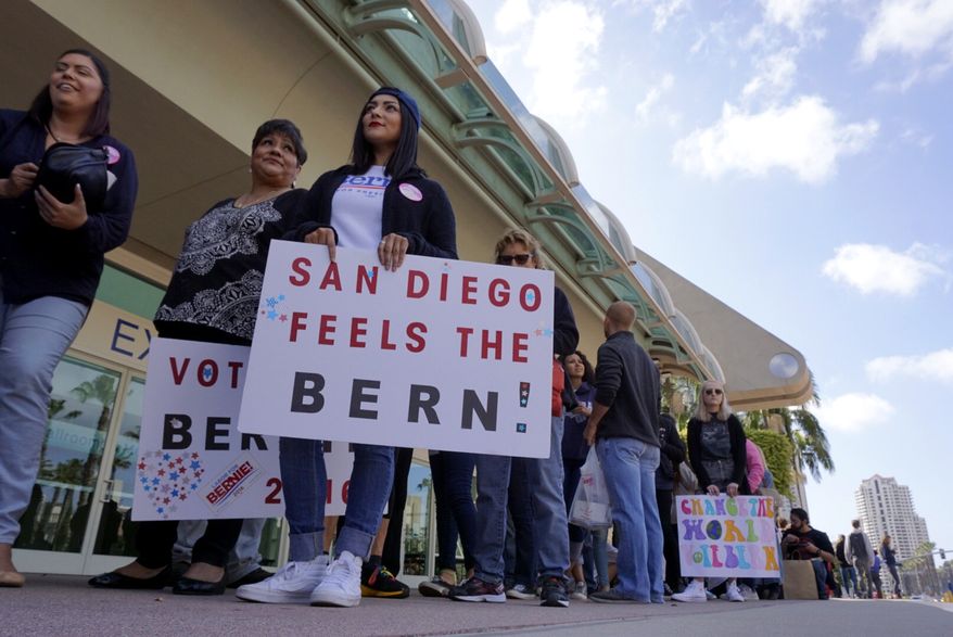 Melody Herrera stands by her sign as she and other people wait to get into the San Diego Convention Center for Democratic presidential candidate Bernie Sanders' campaign rally in San Diego on Tuesday, March 22, 2016. (Hayne Palmour IV/The San Diego Union-Tribune via AP) MANDATORY CREDIT