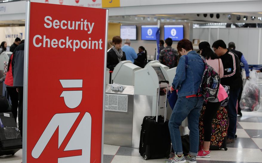 Passengers check into their flights near a security checkpoint sign at O'Hare International Airport on Tuesday, March 22, 2016 in Chicago. The airport attack in Brussels highlights one of the most vulnerable stages of aviation security: the time travelers spend between the curb and the checkpoint. (AP Photo/Teresa Crawford)