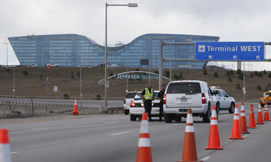 Denver Police Department officers block a ramp to the west side of the terminal at Denver International Airport after part of the facility was evacuated because of suspicious packages found in the terminal Tuesday, March 22, 2016, in Denver. The top two levels of the west side of the main terminal were evacuated before the bomb squad determined that the packages were not a threat. (AP Photo/David Zalubowski)