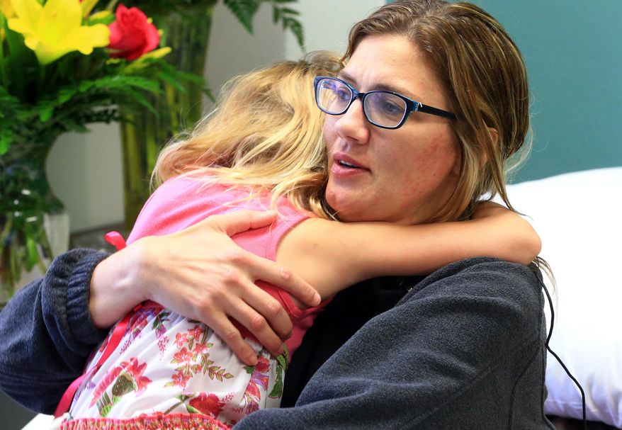 In this Tuesday, March 22, 2016, Tracy Anderwald hugs her daughter Allison Anderwald at Christus Spohn Hospital Memorial in Corpus Christi, Texas. Allison has been credited with saving her mother's life after she fell unconscious in their swimming pool in South Texas. (Gabe Hernandez/Corpus Christi Caller-Times via AP) MANDATORY CREDIT; MAGS OUT; TV OUT