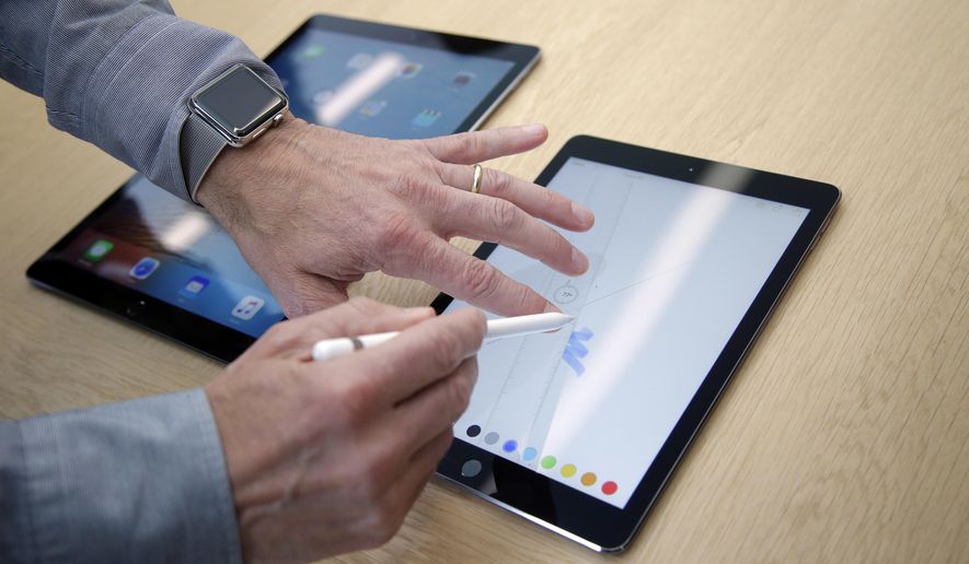 FILE - In this Monday, March 21, 2016, file photo, members of the media and invited guests take a look at the new iPad Pro during an event at Apple headquarters in Cupertino, Calif. Tablets may never be the consumer sensation they once were, but they are finding new life among professionals. Microsoft made a bet on this market with the Surface business. Now, Apple is expanding that push with a second iPad Pro model, while Samsung launched its own. These new tablets, with higher price tags, appeal to people looking for productivity. (AP Photo/Marcio Jose Sanchez, File)