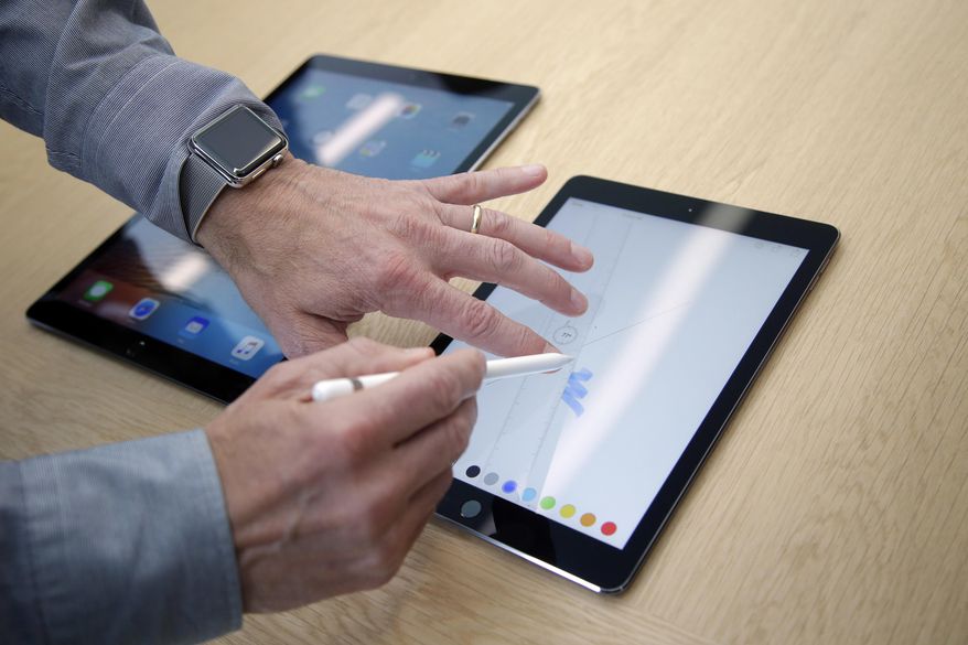 FILE - In this Monday, March 21, 2016, file photo, members of the media and invited guests take a look at the new iPad Pro during an event at Apple headquarters in Cupertino, Calif. Tablets may never be the consumer sensation they once were, but they are finding new life among professionals. Microsoft made a bet on this market with the Surface business. Now, Apple is expanding that push with a second iPad Pro model, while Samsung launched its own. These new tablets, with higher price tags, appeal to people looking for productivity. (AP Photo/Marcio Jose Sanchez, File)