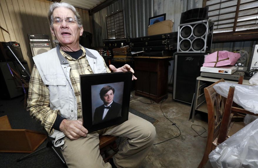 In this March 20, 2016 photograph, Michael Usry Sr. holds a portrait of his then 19-year-old son, Michael Jr., at his Clinton, Miss., garage. Usry recalls how his son became a prime suspect for a short time in a Idaho Falls murder and rape case, although never charged, because of DNA Usry donated to a genealogical research effort backed by the Mormon Church and operated by Brigham Young University scientists as part of the church's deep involvement in genetic research. (AP Photo/Rogelio V. Solis)