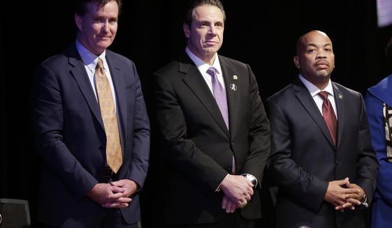 FILE--In this Jan. 13, 2016 file photo, New York Gov. Andrew Cuomo, center, stands with Senate Majority Leader John Flanagan, left, R-Smithtown, and Assembly Speaker Carl Heastie, D-Bronx, before delivering his State of the State address and executive budget proposal at the Empire State Plaza Convention Center in Albany, N.Y.  The biggest proposals of the year in Albany - a $15 minimum wage, paid family leave, higher taxes on millionaires, ethics reforms and a big jump in school spending _ will live or die this week as lawmakers piece together next year&#39;s state budget. (AP Photo/Mike Groll, File)