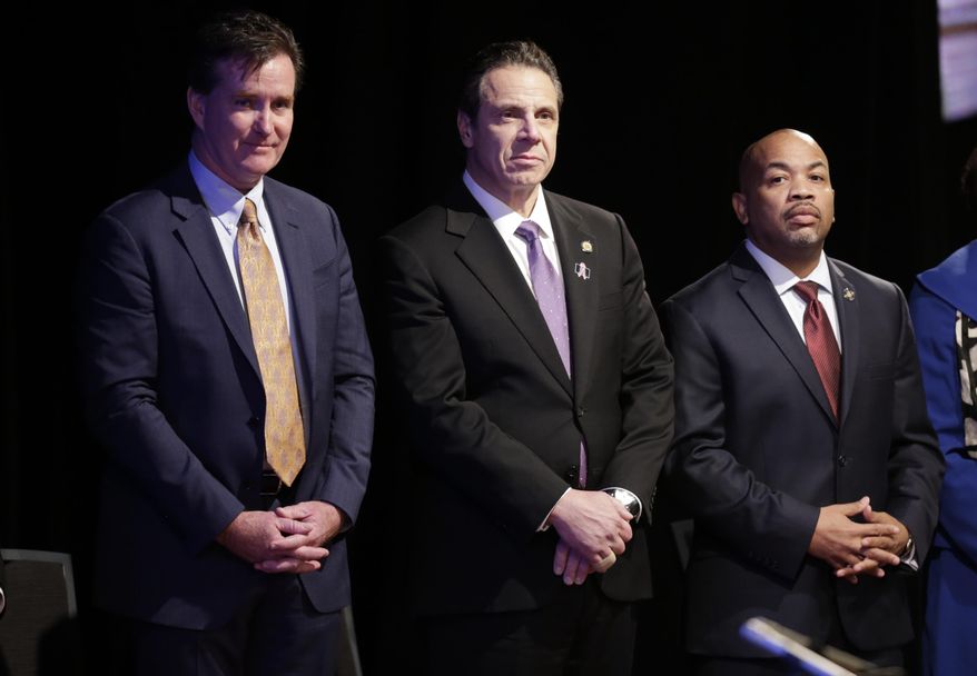 FILE--In this Jan. 13, 2016 file photo, New York Gov. Andrew Cuomo, center, stands with Senate Majority Leader John Flanagan, left, R-Smithtown, and Assembly Speaker Carl Heastie, D-Bronx, before delivering his State of the State address and executive budget proposal at the Empire State Plaza Convention Center in Albany, N.Y. The biggest proposals of the year in Albany - a $15 minimum wage, paid family leave, higher taxes on millionaires, ethics reforms and a big jump in school spending _ will live or die this week as lawmakers piece together next year's state budget. (AP Photo/Mike Groll, File)