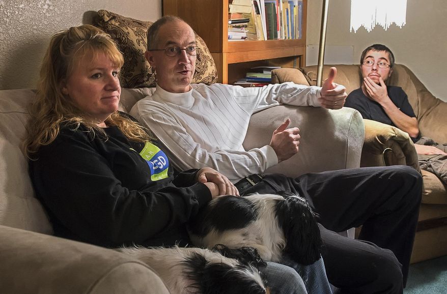 ADVANCE FOR WEEKEND EDITIONS - In this March 18, 2016 photo, Jina and Jerry Ezell talk about the confounding disease of their adopted son, Cody, sitting at right, at home in Longview, Wash. Ezell said he can lead a fairly normal life, despite living with a disease shared by only about 1,200 people nationally. (Bill Wagner/The Daily News via AP) MANDATORY CREDIT