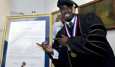 Entertainer and entrepreneur Sean Combs poses next to his honorary degree of Doctor of Humanities during the graduation ceremony at Howard University in Washington, on Saturday, May 10, 2014.( AP Photo/Jose Luis Magana)