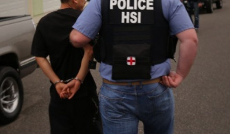 In this handout photo, an HSI special agent escorts arrested individual to transport vehicle. One thousand one hundred and thirty-three individuals were arrested across the U.S. during Project Shadowfire, a 5-week operation led by U.S. Immigration and Customs Enforcement’s (ICE) Homeland Security Investigations (HSI) that ended March 18. 