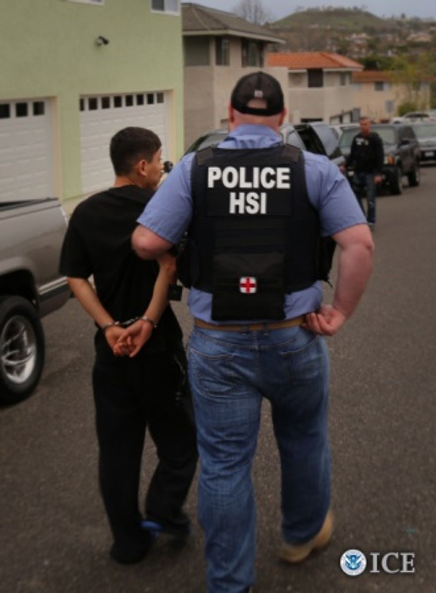 In this handout photo, an HSI special agent escorts arrested individual to transport vehicle. One thousand one hundred and thirty-three individuals were arrested across the U.S. during Project Shadowfire, a 5-week operation led by U.S. Immigration and Customs Enforcement’s (ICE) Homeland Security Investigations (HSI) that ended March 18.