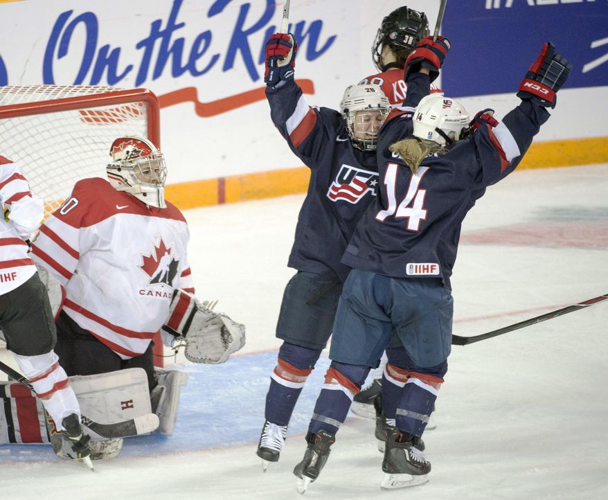 Team USA's Brianna Decker (14) celebrates with teammate Kendall Coyne (26) after scoring the second goal against Team Canada goaltender Emerance Maschmeyer during third period action at the women's world hockey championships Monday, March 28, 2016 in Kamloops, Canada. (Ryan Remiorz/The Canadian Press via AP)