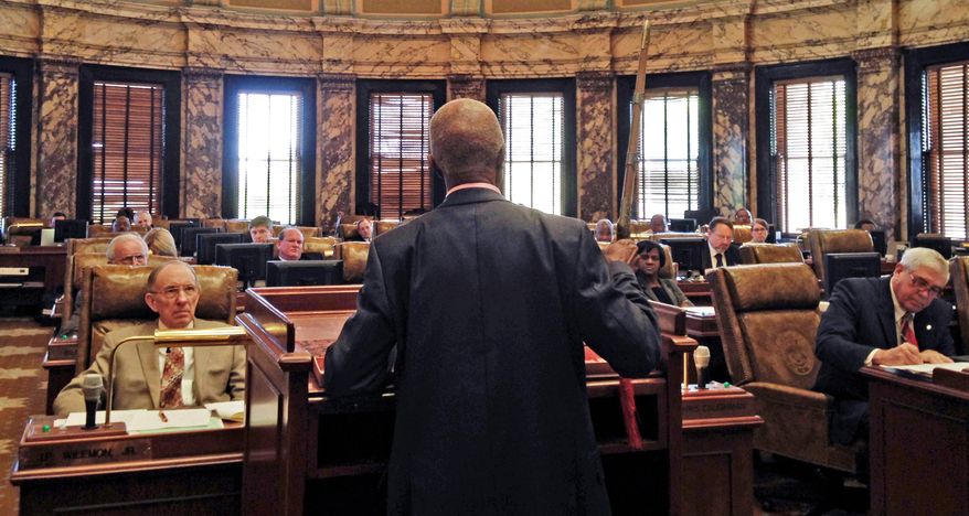 Sen. Hillman Frazier, D-Jackson, brandishes a sheathed sword Tuesday, March 29, 2016, during debate over House Bill 786, at the Capitol in Jackson, Miss. Frazier opposed the bill, which would grant immunity to trained church security teams that shoot people trying to commit violent crimes. Frazier said the bill went against Christian teaching, recounting the story of Jesus healing a servant of a high priest after a disciple cut off the servant’s ear with a sword. (AP Photo/Jeff Amy)