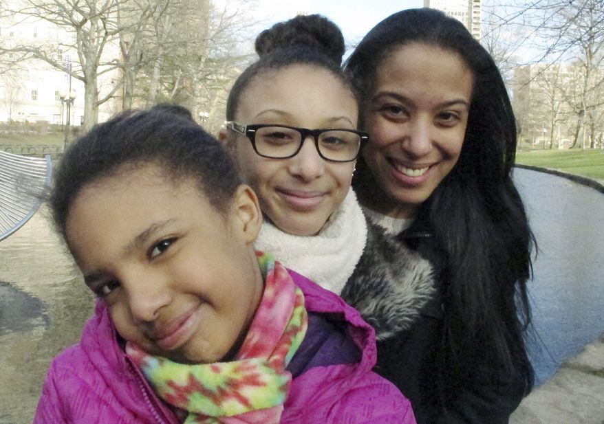 In this Monday, March 21, 2016 photo, Adelaida Torres, right, poses with daughters Elizabeth, left, and Gloria, center, in Hartford, Conn. Torres believes she never would have won custody of her two daughters in 2013 during a bitter court fight with her now-ex-husband if not for the free legal help from attorney Linda Allard and Greater Hartford Legal Aid. Connecticut lawmakers are considering a bill that would create a task force to look into expanding the right to free lawyers for the poor in civil cases. (AP Photo/Dave Collins)