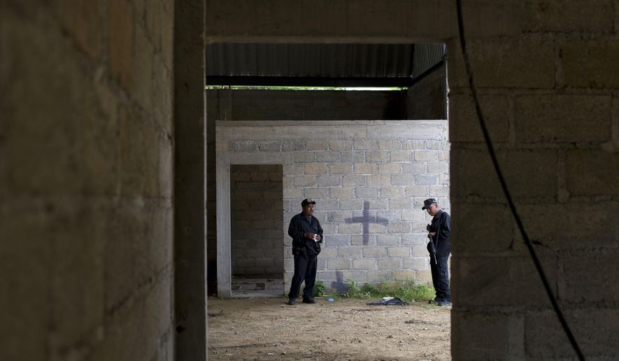 FILE - In this July 3, 2014, file photo, state police stand inside a warehouse where a black cross covers a wall near blood stains on the ground, after a shootout between Mexican soldiers and alleged criminals on the outskirts of the village of San Pedro Limon, in Mexico state, Mexico. Leading Mexican human rights groups announced Wednesday, March 30, 2016, that a military court acquitted six of seven soldiers charged with breach of discipline in the 2014 killings. (AP Photo/Rebecca Blackwell, File)