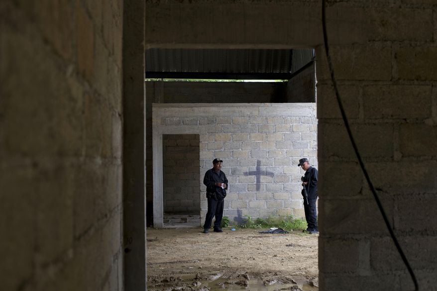 FILE - In this July 3, 2014, file photo, state police stand inside a warehouse where a black cross covers a wall near blood stains on the ground, after a shootout between Mexican soldiers and alleged criminals on the outskirts of the village of San Pedro Limon, in Mexico state, Mexico. Leading Mexican human rights groups announced Wednesday, March 30, 2016, that a military court acquitted six of seven soldiers charged with breach of discipline in the 2014 killings. (AP Photo/Rebecca Blackwell, File)