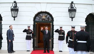 In this file photo, Chinese president Xi Jinping, center, waves after he is greeted by Ambassador Peter A. Selfridge, left, Chief of Protocol of the United States, upon his arrival at the White House in Washington, Thursday, March 31, 2016.  (Andrew Harnik/AP) **FILE**