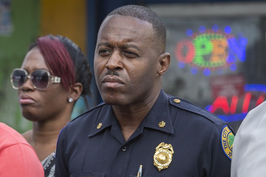 In this Jan. 2, 2016, photo, Miami Police Maj. Delrish Moss stands among the Miami-Dade officials who announced the arrest of Willie "Pee Wee" Wilcher in Liberty City, Fla. Moss was announced as police chief in Ferguson, Mo., Thursday, March 31, 2016, putting a black man in charge of a mostly white department that serves a town where African-Americans make up two-thirds of the residents. (Matias J. Ocner/The Miami Herald via AP) MAGS OUT; MANDATORY CREDIT