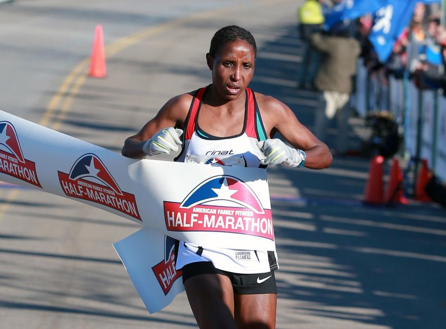 FILE - In this Nov. 15, 2014, file photo, Lilian Mariita, of Kenya, wins the women's division of a half-marathon in Richmond, Va. The 27-year-old's racing career is over, and now she is back at square one: in Nyaramba, the muddy tea-plantation village in western Kenya she thought she'd escaped in 2011, when she left for the promise of a new life pounding American roads. (Daniel Sangjib Min/Richmond Times-Dispatch via AP) /Richmond Times-Dispatch via AP) MANDATORY CREDIT