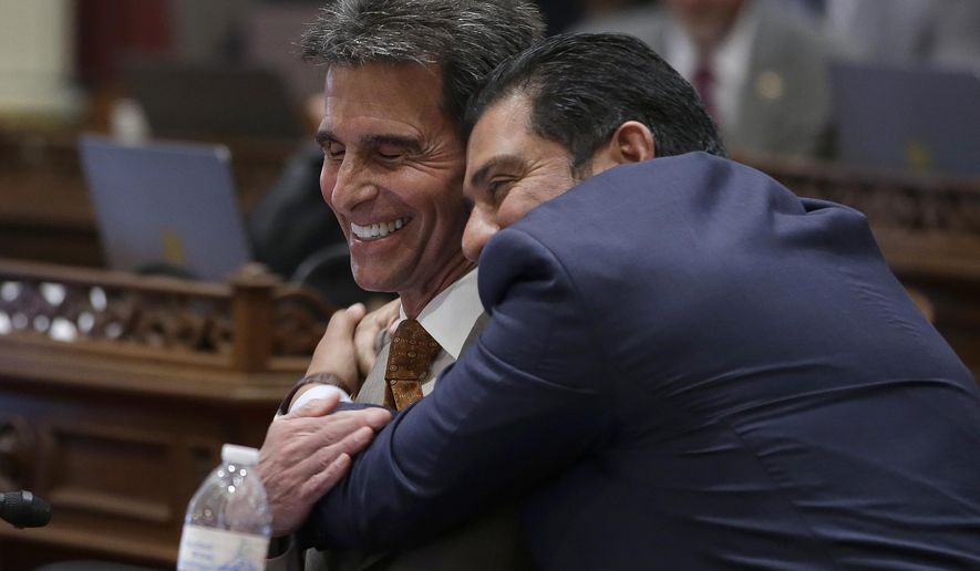 State Sen. Mark Leno, D-San Francisco, left, one of the authors of a bill to raise California's minimum wage, is hugged by Sen. Ben Hueso, D-San Diego, as the Senate voted on the bill, Thursday, March 31, 2016, in Sacramento, Calif. The bill, SB3, to gradually raise the state's minimum wage to a nation-leading $15 an hour by 2022, was approved by both houses of the Legislature and sent to Gov. Jerry Brown. (AP Photo/Rich Pedroncelli)