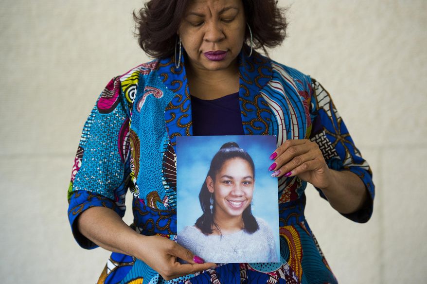 In this photo taken March 29, 2016, Nardyne Jefferies holds a photo of her late daughter Brishell in Arlington, Va. Brishell Jones was 16 when she and several other teenagers were standing on a street corner in Washington, D.C., after attending a funeral for a friend who was killed over a missing bracelet. (AP Photo/Molly Riley)