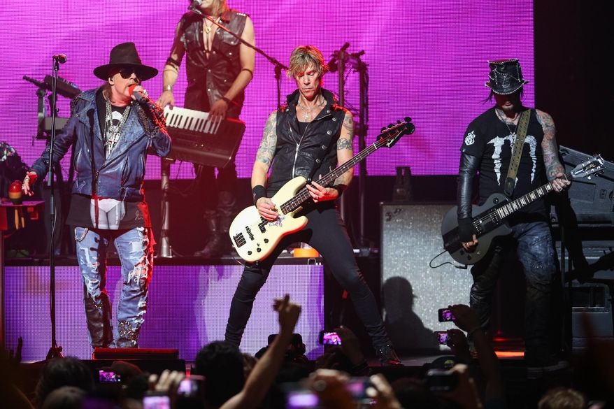 FILE - In this April 23, 2014 file photo, Axl Rose, from left, Duff McKagan and DJ Ashba of Guns N' Roses perform on stage at the 6th Annual Revolver Golden Gods Award Show at Club Nokia in Los Angeles. Crowds thronged for tickets after a surprise announcement that Guns N' Roses would play a concert Friday night, April 1, 2016, at West Hollywood's famed Troubadour music venue. The band announced on its website and in a press release that a limited number of tickets at a very old-school price of $10 apiece would be available at noon at the former location of the famous Tower Records store on the Sunset Strip. (Photo by Paul A. Hebert/Invision/AP, File)