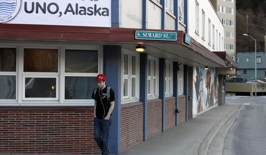 Oliver Coleman passes underneath a sign welcoming people to UNO, Alaska during his walk to work on Friday, April 1, 2016, in Juneau, Alaska. The capital city of Alaska is going by a new name for April Fool's Day - Uno. It's a play on words for the city name of Juneau and part of a promotion with game and toy-maker Mattel Inc., which is drawing attention to new wild cards in its UNO card game. (AP Photo/Rashah McChesney)