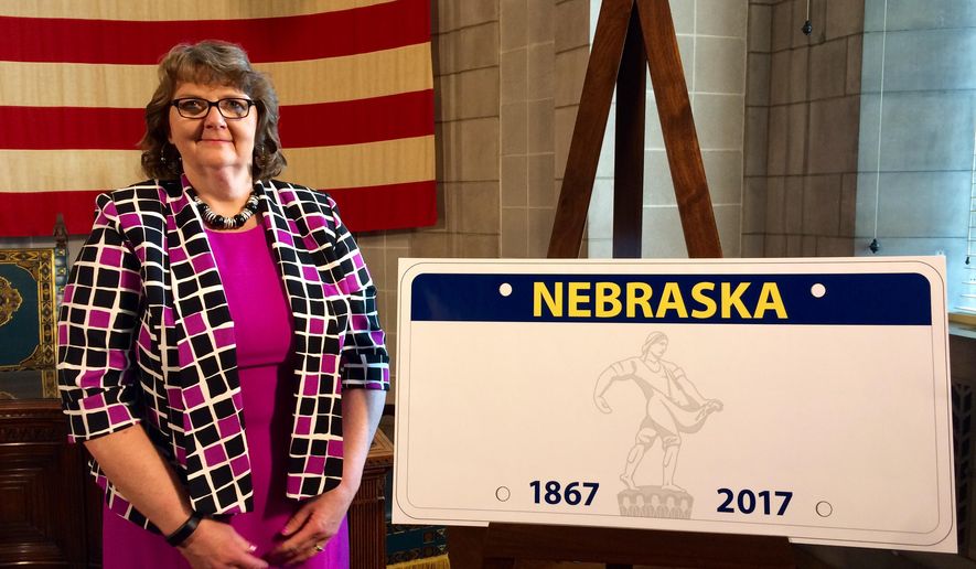 FILE - In a Tuesday, March 22, 2016 file photo, Nebraska Department of Motor Vehicles Director Rhonda Lahm poses next to a design for the the state’s new standard license plate at a news conference, at the Capitol in Lincoln, Neb. Nebraska is halting production of a new, widely mocked license plate after officials learned that the state icon depicted at the center wasn't drawn accurately. The license plate is supposed to show the Nebraska Sower, a statue of a man throwing seeds from atop the state Capitol. The governor's office said Friday, April 1, 2016, that the image on the plates used elements from a different artwork. (AP Photo/Anna Gronewold, File)