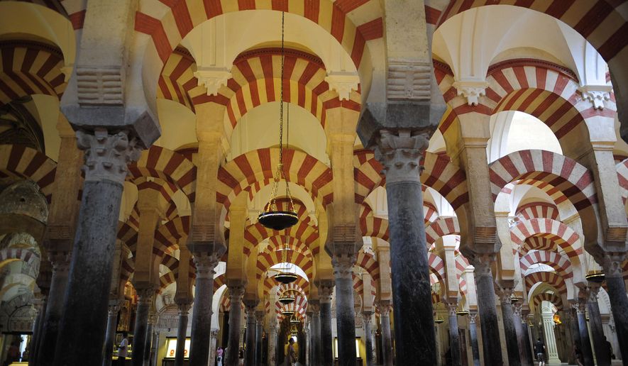 FILE - In this Aug. 6, 2009 file photo, tourists visit the Great Mosque of Cordoba in southern Spain. Catholic Church authorities in the southern Spanish city of Cordoba have agreed to restore the Islamic reference in the name of the city's famed mosque-cathedral and stop referring to it as simply "The Cordoba Cathedral." The decision was welcomed Friday April 1, 2016 by the Mosque-Cathedral protest group that complained that church policy of calling the monument "The Cordoba Cathedral" on pamphlets and tickets in recent years was an attempt to blot out its Islamic past and confused tourists.The mosque was built after the Moorish invasion of Spain in the 8th century but was transformed into a cathedral in the 13th century. It is a UNESCO World Heritage. (AP Photo/Manu Fernandez, File)