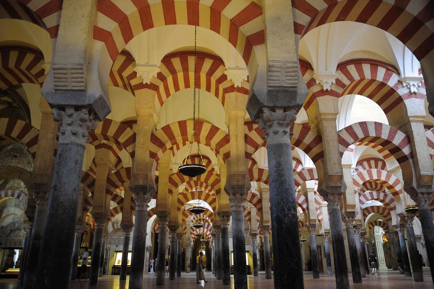 FILE - In this Aug. 6, 2009 file photo, tourists visit the Great Mosque of Cordoba in southern Spain. Catholic Church authorities in the southern Spanish city of Cordoba have agreed to restore the Islamic reference in the name of the city's famed mosque-cathedral and stop referring to it as simply "The Cordoba Cathedral." The decision was welcomed Friday April 1, 2016 by the Mosque-Cathedral protest group that complained that church policy of calling the monument "The Cordoba Cathedral" on pamphlets and tickets in recent years was an attempt to blot out its Islamic past and confused tourists.The mosque was built after the Moorish invasion of Spain in the 8th century but was transformed into a cathedral in the 13th century. It is a UNESCO World Heritage. (AP Photo/Manu Fernandez, File)