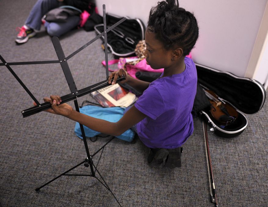 A'Taliya Bass, 11, sets up her music stand before playing violin with the Mizzou String Project in Loeb Hall on Feb. 26, 2016 in Columbia, Mo. Bass was born premature at 27 weeks and survived. Medical advancements in the last 50 years have dramatically increased the survival rate for infants born up to 4 1/2 months prematurely. (Mikala Compton/Missourian via AP) MANDATORY CREDIT