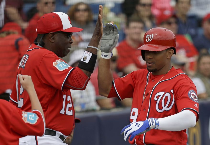 Washington Nationals manager Dusty Baker, left, high fives Ben Revere, right, after he hit a home run in a spring training baseball game against the Detroit Tigers, Saturday, March 5, 2016, in Viera, Fla. (AP Photo/John Raoux)