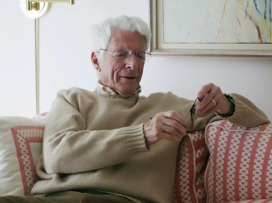 This February 2016 photo provided by Dan Shifrin shows his father, 93-year-old Edwin Shifrin at home in Clayton, Mo., looking at a prisoner-of-war medal he just received for his World War II military service. The award was expedited by U.S. Sen. Claire McCaskill of Missouri after she was approached by Shifrin's family about his clever escape from a Nazi prison camp. That may never have come to light if not for the efforts of son Dan Shifrin, who says he was able to learn about the escape by digging through old news reports and his father's military records. (Marianne Shifrin/Dan Shifrin via AP)