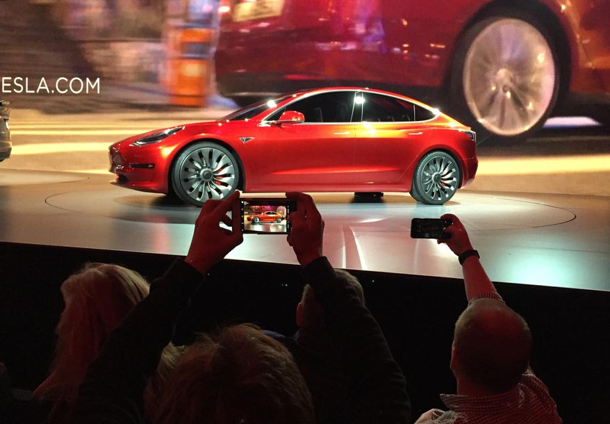 CORRECTS SPELLING OF PHOTOGRAPHER'S LAST NAME TO PRITCHARD, NOT PRICHARD - Tesla Motors unveils the new lower-priced Model 3 sedan at the Tesla Motors design studio in Hawthorne, Calif., Thursday, March 31, 2016. It doesn't go on sale until late 2017, but in the first 24 hours that order banks were open, Tesla said it had more than 115,000 reservations. Long lines at Tesla stores, reminiscent of the crowds at Apple stores for early models of the iPhone, were reported from Hong Kong to Austin, Texas, to Washington, D.C. Buyers put down a $1,000 deposit to reserve the car. (AP Photo/Justin Pritchard)