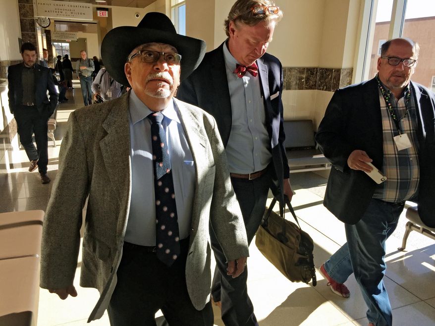 Former New Mexico state Sen. Phil Griego, left, and his attorney Tom Clark, center, walk out of an arraignment in Santa Fe District Court in Santa Fe, N.M., Monday, April 4, 2016. The Democrat from San Jose was released pending trial after pleading not guilty to fraud and bribery charges stemming from his role in the sale of a state-owned building in Santa Fe. (AP Photo/Morgan Lee)