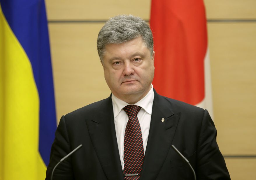 Ukrainian President Petro Poroshenko, left, listens to Japanese Prime Minister Shinzo Abe speaking during a joint press conference following their meeting at the latter's official residence in Tokyo, Wednesday, April 6, 2016. Poroshenko was in Japan to meet Abe and business leaders. (Kimimasa Mayama/Pool Photo via AP)