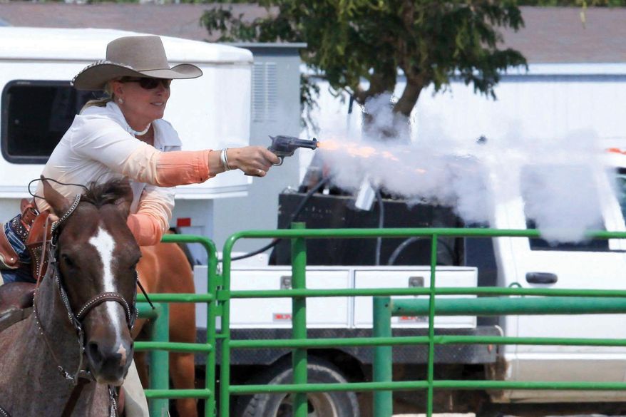 In this May 2015 photo provided by Gremp Photography via the Wyoming Desperados mounted shooting club, Nicole "Scooter" Singbeil of Powell, Wyo. shoots a pistol at a target while riding a horse in Powell, Wyo. Singbeil says the competition involves marksmanship and horsemanship, and most horses take to the competition fairly easily if they are introduced to it properly. (Chuck Gremp/Gremp Photography/Wyoming Desperados via AP)