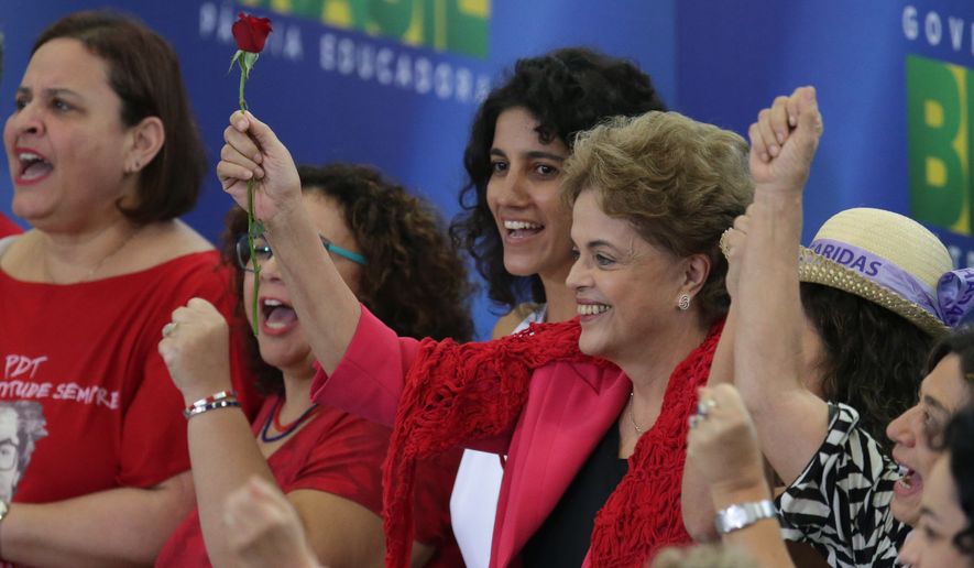 Brazil&#x27;s President Dilma Rousseff raises a rose, during a Women in Defense of Democracy Meeting, at the Planalto Presidential Palace, in Brasilia, Brazil, Thursday, April 7, 2016. The women representing social movements and trade unions who are against Rousseff&#x27;s removal from office, gathered to show their support. (AP Photo/Eraldo Peres) ** FILE **