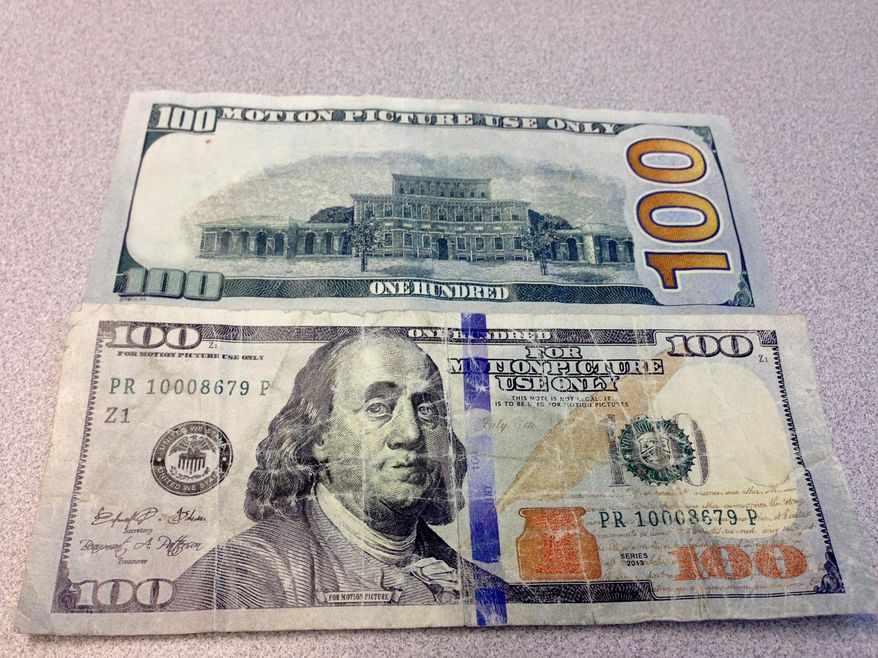 This April 6, 2016 photo, shows the front and back of a fake $100 bill, in Waterloo, Iowa. Waterloo police are having a hard time cracking down on the use of fake $100 bills meant to be props for movies and music videos at local stores. Over the past few months, there have been about a dozen cases in which the fake bills have been used in transactions in Waterloo, the Waterloo-Cedar Falls Courier reported. At least one person has been arrested in connection with the fake money. (Jeff Reinitz /The Courier via AP) MANDATORY CREDIT