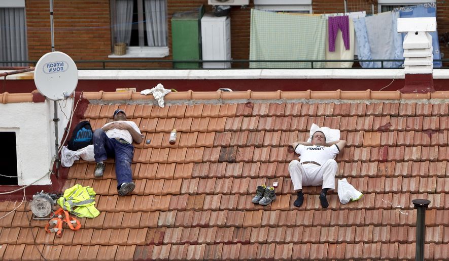 FILE - In this Oct. 10, 2012 file photo, two workers take a nap on a roof in Madrid, Spain. Political parties are promising to turn the clock back in Spain and eliminate a time quirk dating from World War II, a move that could radically change Spaniards’ eating and sleeping habits, including the celebrated siesta. Until the 1940s, Spain was on the same Greenwich Mean Time as Britain and Portugal, being in roughly the same latitude. “We cannot lose contact with Europe. The rationalization of the timetables of work shifts and government institutions is of capital importance,” Spain’s acting Prime Minister Mariano Rajoy said last April 2, 2016. (AP Photo/Alberto Di Lolli, File)