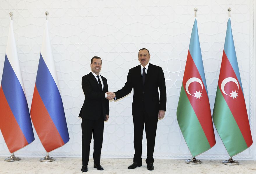 Azerbaijan President Ilham Aliyev, right, and Russian Prime Minister Dmitry Medvedev shake hands during their meeting in Baku, Azerbaijan, Friday, April 8, 2016. (Alexander Astafyev/Sputnik, Government Pool Photo via AP)