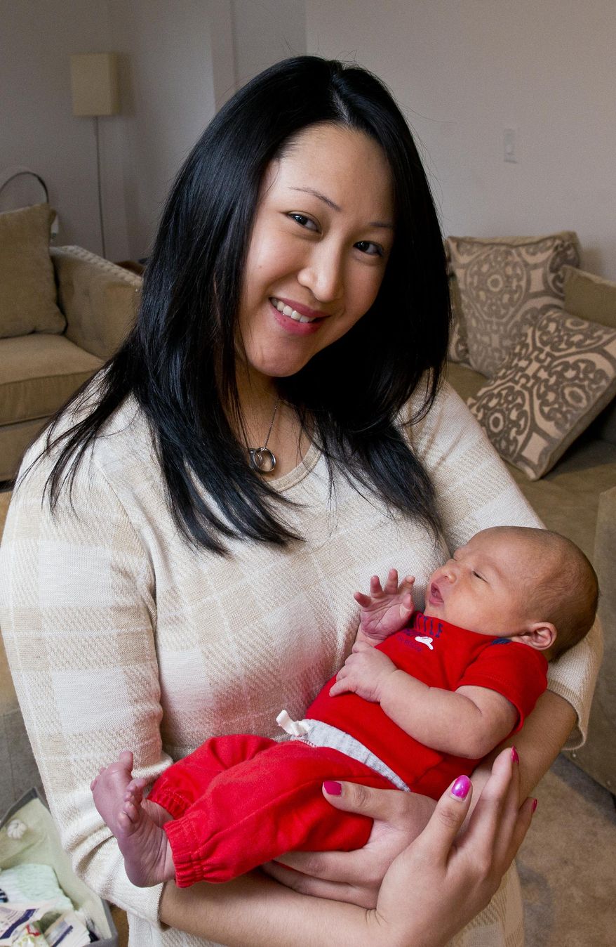 ADVANCED FOR RELEASE SUNDAY, APRIL 10, 2016 Kate Rodeman with her week-old son Dennis Blake Rodeman, sit in their house in Laingsburg, Mich., Monday, March 28, 2016. Rodeman's husband, Dennis, was killed last fall after he was struck by a vehicle while collecting donations for the "Fill the Boot" campaign. (Dave Wasinger/Lansing State Journal via AP)