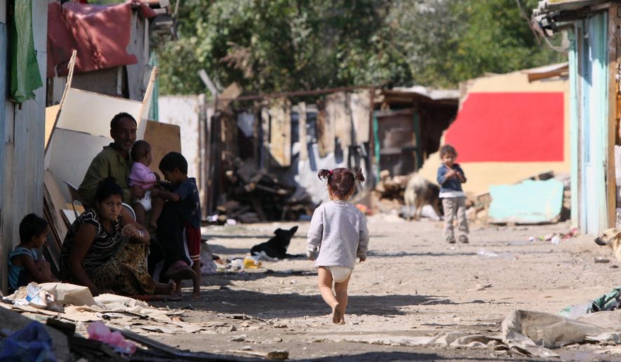 FILE- In this Sept. 28, 2010 file photo, a barefoot Roma child walks at a dirt road in Cesmin Lug Roma camp in the northern Kosovo's town of Mitrovica. A U.N. human rights tribunal in Kosovo said Friday, April 8, 2016, the world body should apologize and compensate the Roma community for the health impact of being housed on lead-poisoned sites after the war in 1999. (AP Photo/Visar Kryeziu)