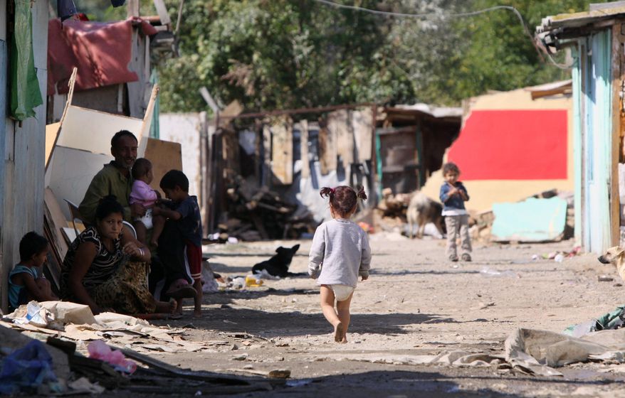 FILE- In this Sept. 28, 2010 file photo, a barefoot Roma child walks at a dirt road in Cesmin Lug Roma camp in the northern Kosovo's town of Mitrovica. A U.N. human rights tribunal in Kosovo said Friday, April 8, 2016, the world body should apologize and compensate the Roma community for the health impact of being housed on lead-poisoned sites after the war in 1999. (AP Photo/Visar Kryeziu)