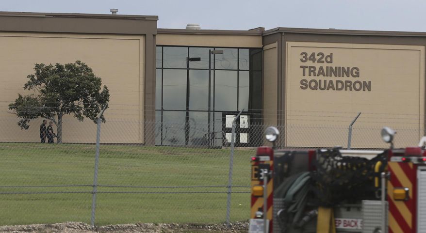 Two Bexar County Sheriff's Deputies, left, stand outside a building near the scene of a shooting at Joint Base San Antonio-Lackland, Friday, April 8, 2016, in San Antonio. (John Davenport/The San Antonio Express-News via AP) RUMBO DE SAN ANTONIO OUT; NO SALES; MANDATORY CREDIT