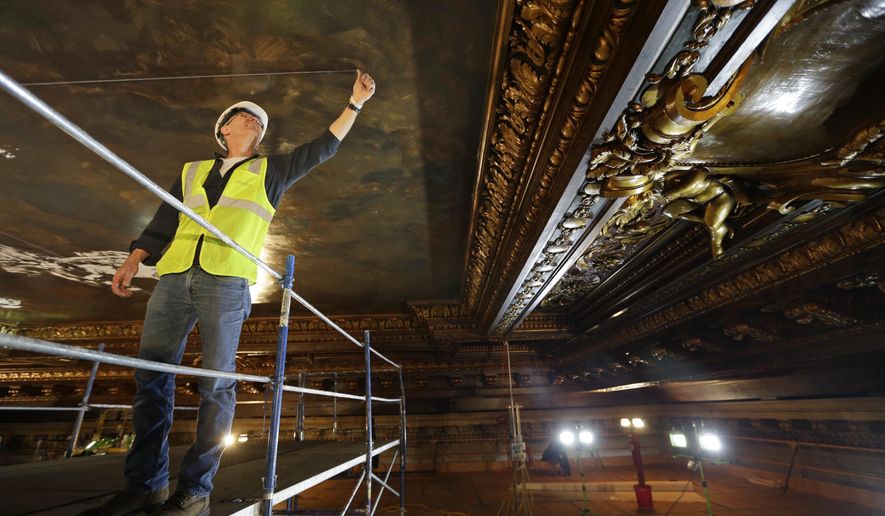 Mural director Bill Mensching helps prepare the ceiling for a new mural in the main catalog room at the New York Public Library in New York, Thursday, April 7, 2016. The library is installing a recreation of the century-old mural in its main catalog room. The original work was painted by the renowned American muralist and Tiffany Studios designer James Wall Finn. (AP Photo/Seth Wenig)
