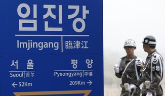 South Korean soldiers walk by a signboard showing the distance to the North Korea&#39;s capital Pyongyang and to South Korea&#39;s capital Seoul from Imjingang Station near the border village of the Panmunjom in Paju, South Korea, Saturday, April 9, 2016. (AP Photo/Lee Jin-man) ** FILE **
